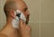 Man shaving his face with the razor blade through shave foam. Men skin care concept.