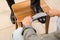 Man shining client`s shoe on wooden stool indoors