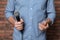 Man in shirt holding microphone near brick wall