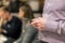 Man in shirt holding smartphone in hand. Businesman using phone during corporate meeting