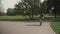 Man in shirt and with rucksack rides bicycle on cycle path in city garden in Munich, Germany. Student cyclist cycling in