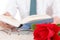 man in shirt and tie with his hands holding open book and leafing through pages