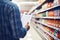 Man with shopping list in aisle at supermarket. Check purchases in grocery store.