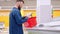 man is shopping in supermarket, choosing frozen vegetables