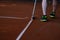 Man in shorts cleaning tennis court lines