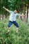 A man in shorts and a shirt is joyful jumping on the grass