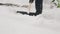 A man with a shovel clears snow around a car after a night of snowstorm.