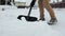 Man with a shovel removes snow. cleaning the area near the house after a snowstorm. slow motion with selective focus.