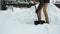 Man with a shovel removes snow. cleaning the area near the house after a snowstorm. slow motion with selective focus.