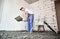 Man shoveling sand-cement mix at construction site.