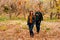 Man showers dry leaves on woman in autumn Park