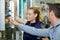 Man showing machinery control panel to female worker