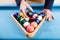 Man showing number eight black pool ball on billiards table