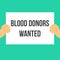 Man showing paper BLOOD DONORS WANTED