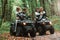 Man showing thumb up. Two couples on a quad bike in the forest during the day