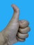 Man showing thumbs up gesture against blue background, closeup