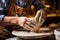 A man is shown in the process of creating a vase by molding clay using his hands and shaping tools, potter using a pottery wheel