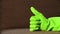 Man shows thumb up in green latex glove
