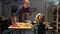 Man shows a wooden product to a boy in a workshop