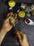 A man shucking fresh oysters with his bare hands on stone table, lemon slices, micro greens, ice, cranberries on table