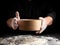 man sifts white wheat flour through a wooden sieve