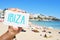 man with a signboard with the word Ibiza, in Ses Figueretes Beach in Ibiza Town, Spain