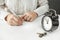 Man signs a blank sheet of document. The contract of sale or deed of gift for the apartment. Alarm clock close-up with the passing