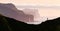 Man silhouette on background of famous Risin og Kellingin rocks