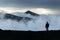 Man silhouette on cloudy mountains