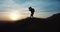 Man in silhouette standing on hill and doing photo of sunset