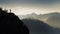 Man silhouette stay on sharp rock peak. Satisfy hiker enjoy view. Tall man on rocky cliff watching down to landscape. Generative