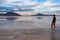 Man sillhoutte walking into sunset of lake Bonneville Salt Flats, Wendover, Western Utah, USA, America. Beautiful summits of