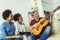 Man singing and playing guitar for his daughter and his wife