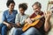 Man singing and playing guitar for his daughter and his wife