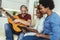 Man singing and playing guitar for his daughter and his wife