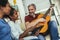 Man singing and playing guitar for his daughter and his wife