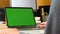 Man Single Tapping a Green Screen Laptop