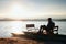 Man sit on abandoned old rusty pedal boat stuck on sand of beach. Wavy water level, island on horizon