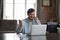 Man sit at desk with laptop enjoy conversation on cellphone