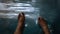 A man siting having fun splashing water from the swimming pool at hotel with his feet during the summer