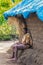 Man sits against hut at Dubare Elephant Camp, Coorg India.