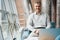 Man sits in an armchair in coworking space among plants