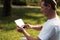 A man sits on a ball for yoga and looks at something on his tablet. He smiles