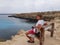 A man sits on a bench on a rock, overlooking the sea. Cyprus, Protaras, May 2018.