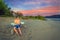 A man sits on a bench on a wild sandy beach on the Volga.