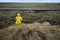 Man sits on cliff opposite country roadway