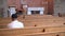 Man sits in an empty church praying