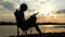 Man Sits on a Folding Chair on The Riverbank, Writes at Sunset in Slo-Mo