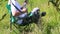 A man sits in a folding picnic chair and works with a smartphone. He takes a break, drinks water from the bottle.