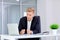 A man sits in front blond frustrated laptop at his deskthe offi